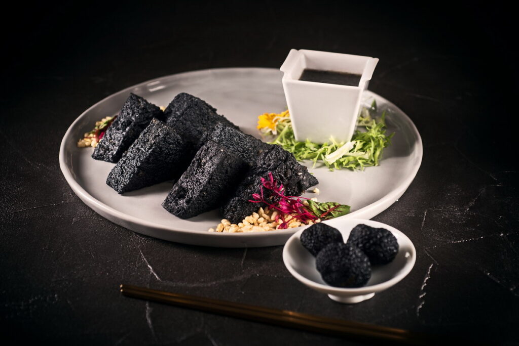 酥炸成烏黑色的「黑松露脆皮豆腐」售價460元,師傅以創新想法,使用雞蛋、無糖豆漿製成豆腐,再用特製脆皮炸至酥脆。(圖_六福旅遊集團提供)