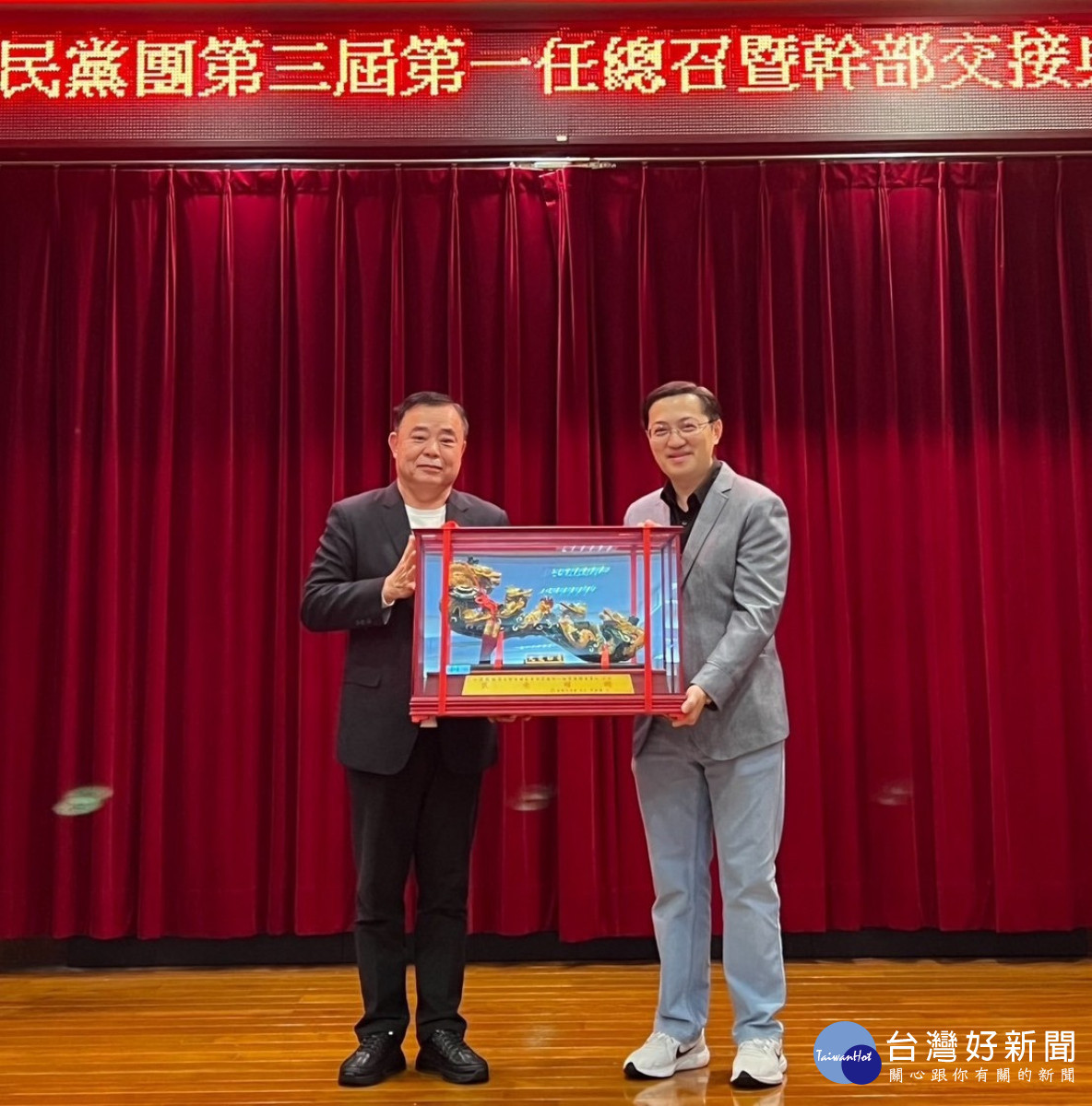 邱奕勝致贈紀念品給新任總召梁為超。<br /><br /> <br /><br />