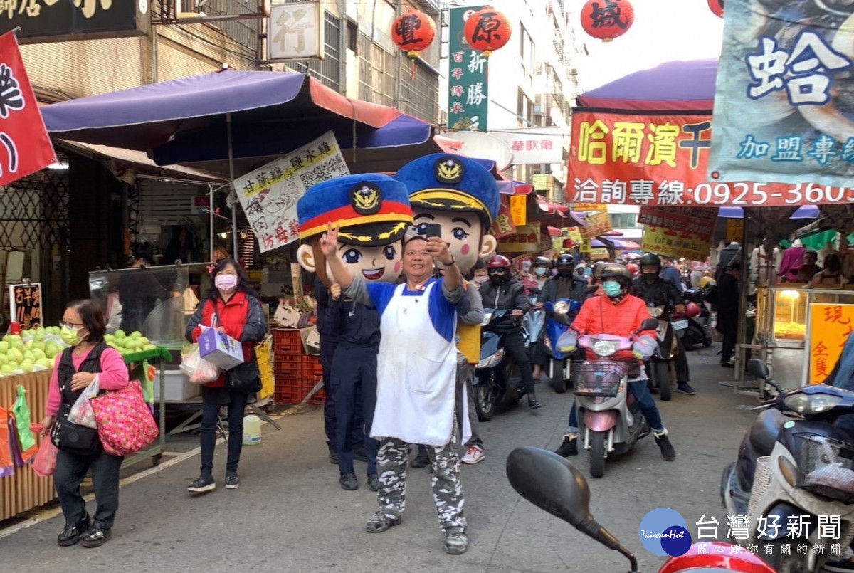 警察大頭娃娃模樣可愛,吸引市場攤商自拍合影。