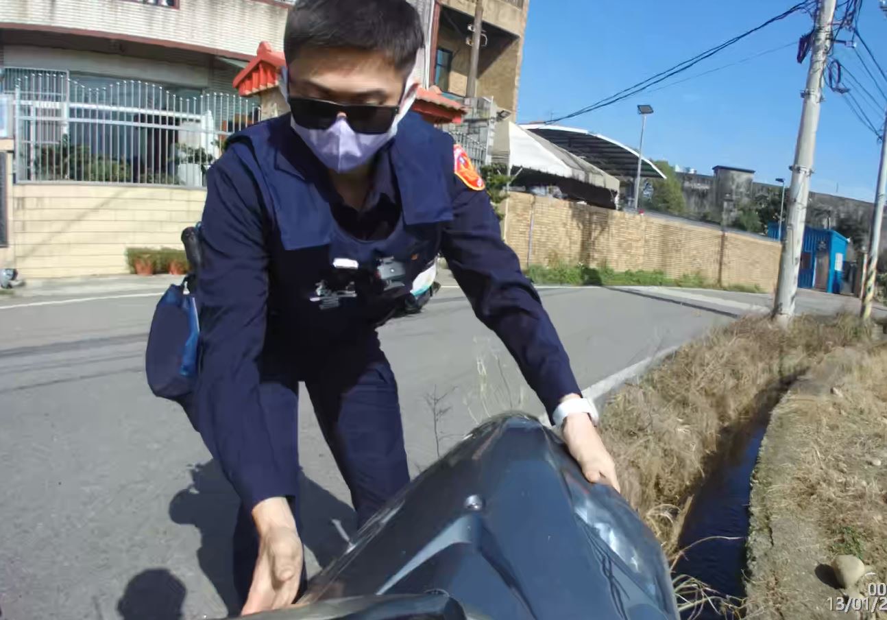 大竹派出所警員張政德及鄭海宏目睹女騎士摔田裡及時救援。(記者宋紹誠翻攝)
