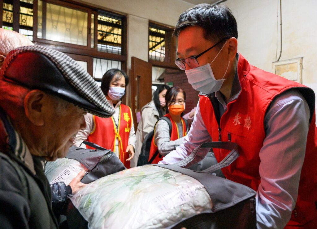 永齡基金會董事長郭守正致贈暖心棉被於華山長輩手中，並與他們話家常。