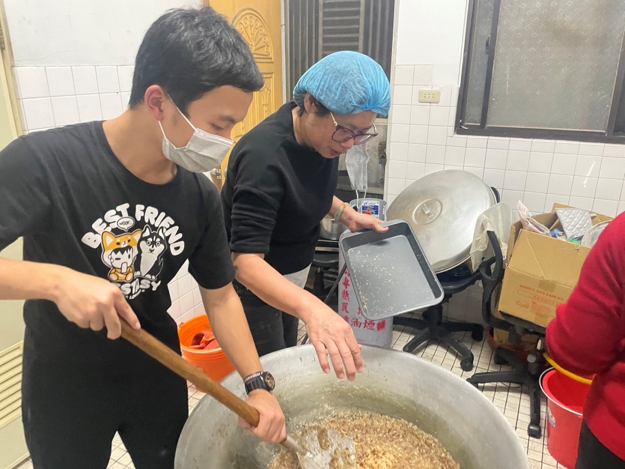 臺中北區賴厝里辦公室及賴厝社區發展協會共同主辦「賴厝傳統年糕技藝傳承暨新春揮毫」活動,仁德醫護專科學校陳冠勇同學 (左1)協助製作糕點。(圖/賴厝社區發展協會提供)