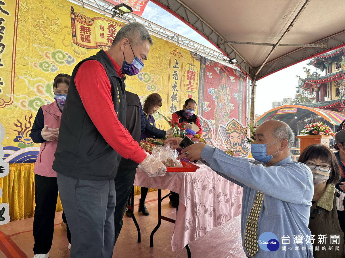 陳主委與香客信眾分享小米糕桃。(記者扶小萍攝)