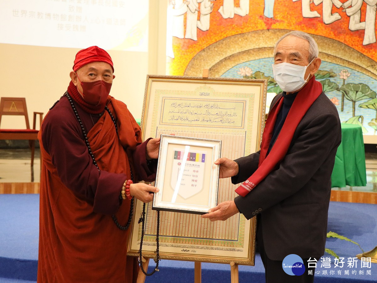 靈鷲山開山住持、世界宗教博物館創辦人心道法師(左),回贈世界宗教博物館錦旗給中國回教協會榮譽理事長倪國安(右),展現跨宗教的情誼