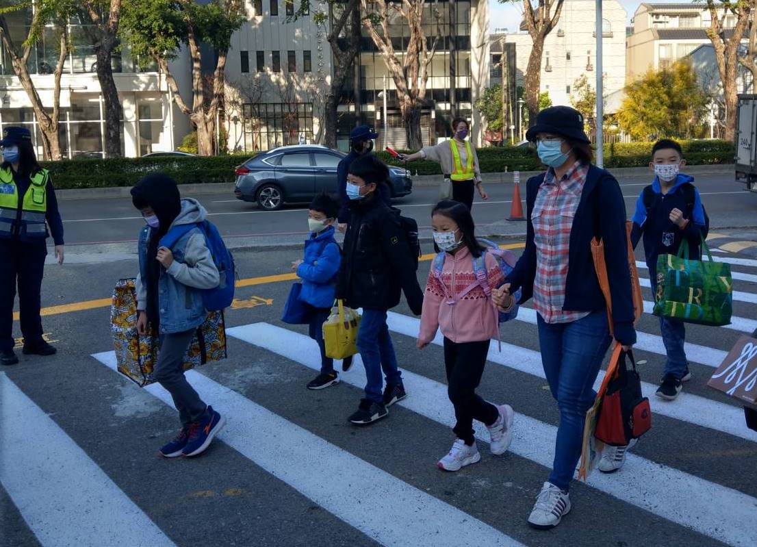 員警在路口指揮交通,引導學童及家長安全過馬路。(圖/記者林㤈輝翻攝)