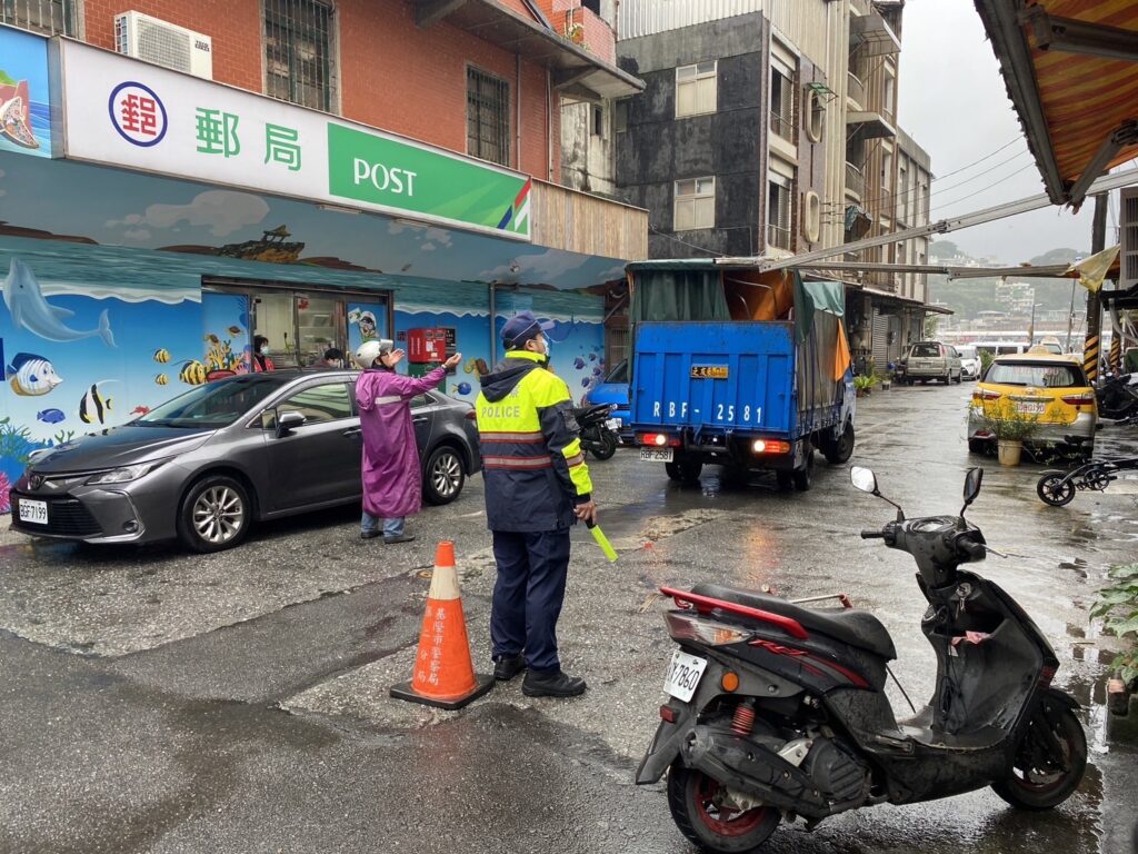 貨車卡住商家頂蓬,警員許文明協助排除並維持交通順暢。