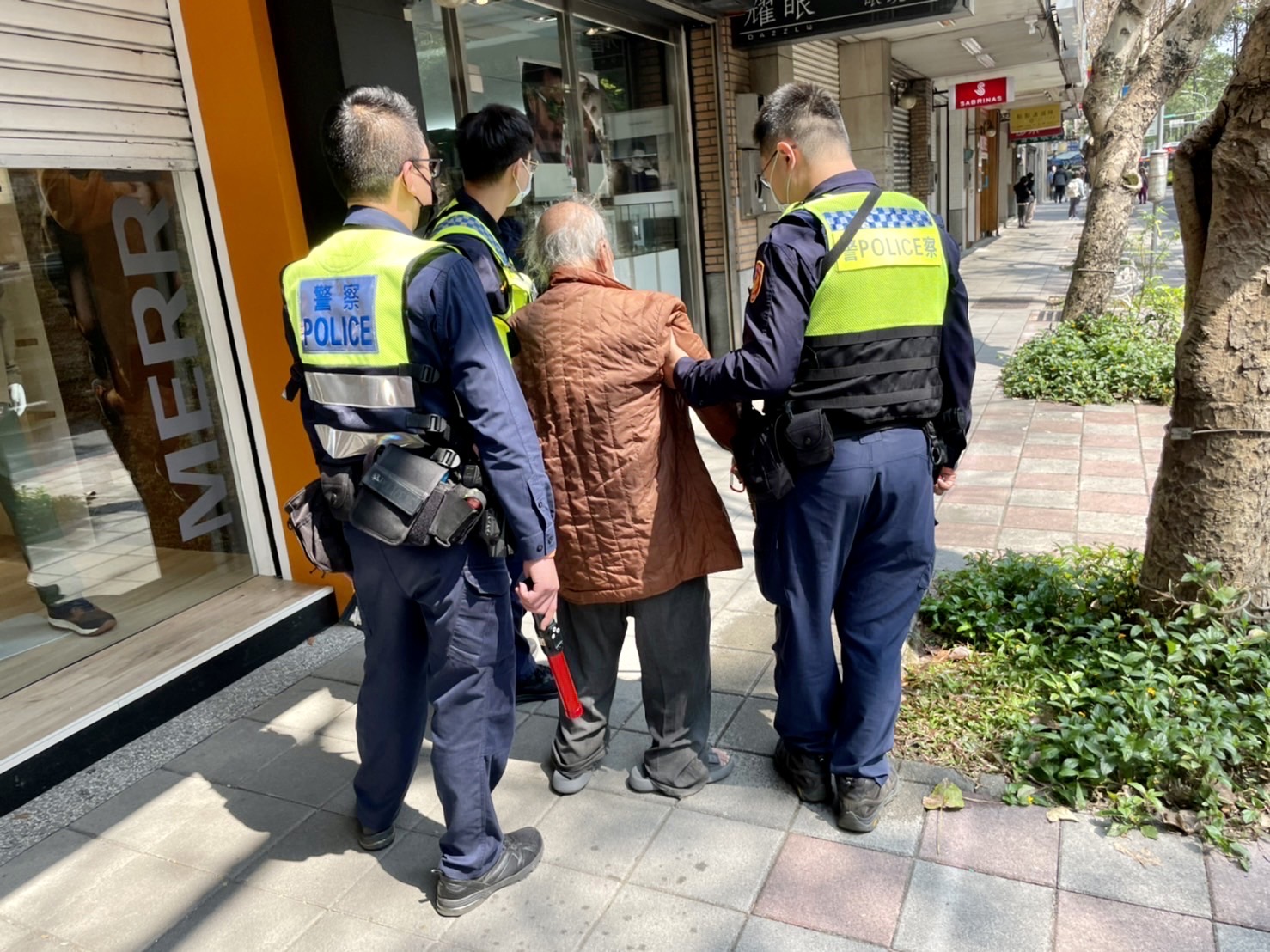 臺北市保安警察大隊員警協助步伐蹣跚受困車陣老翁,順利通過馬路至人行道休息。(記者宋紹誠翻攝)