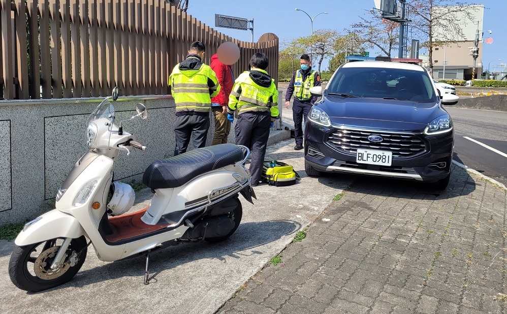 ▲ 梁姓機車騎士載著女友於路中「爆胎」摔倒,員警趕緊上前救援 (圖/台中市警察局 提供)