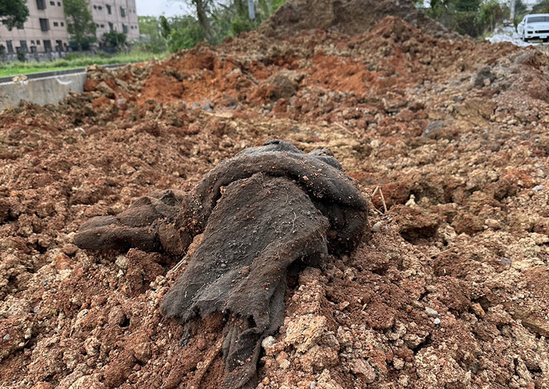 大溪區一處良田遭惡意傾倒大量廢棄土內的廢棄物。(記者范文濱翻攝)