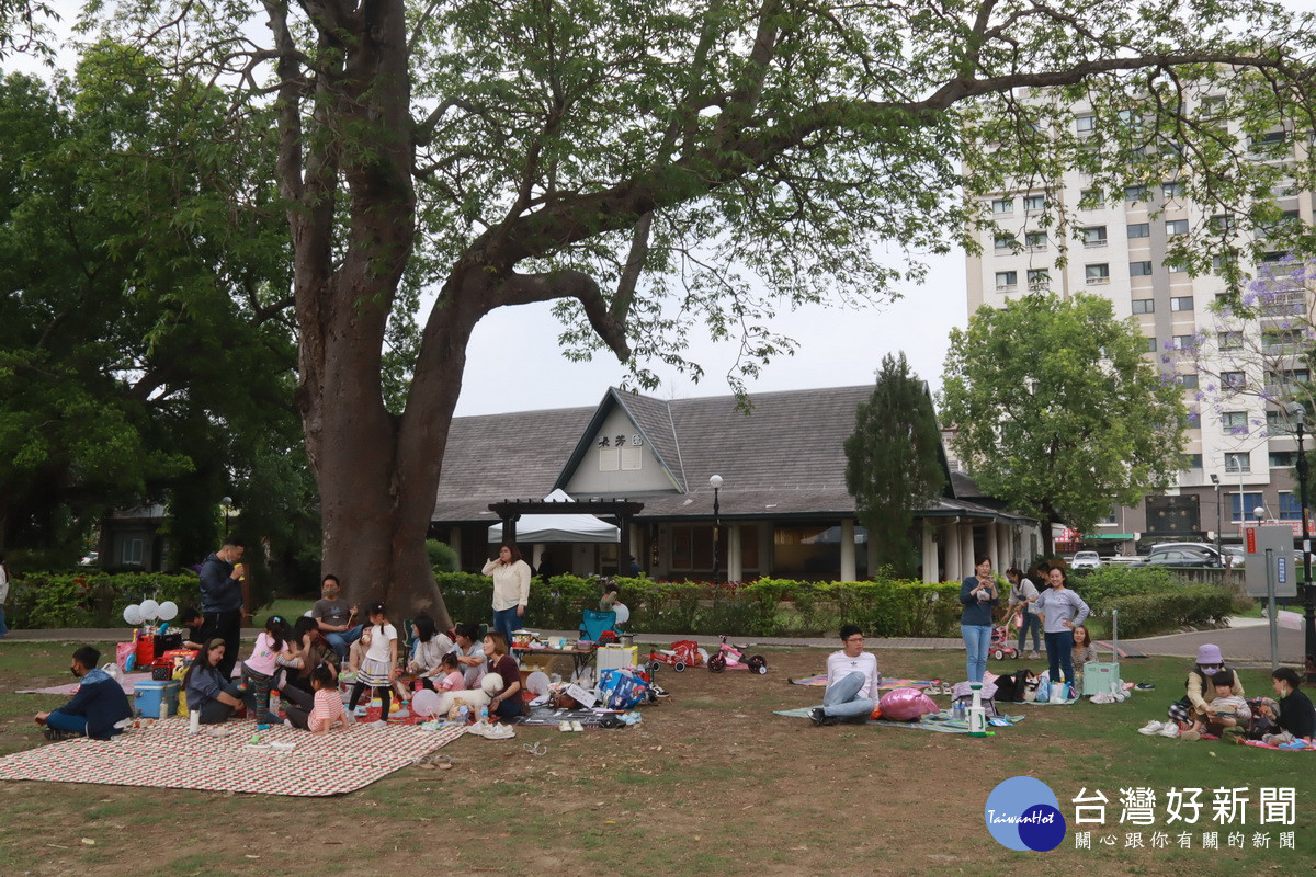 家長帶著孩子來草地野餐享受春風吹拂。(記者扶小萍攝)