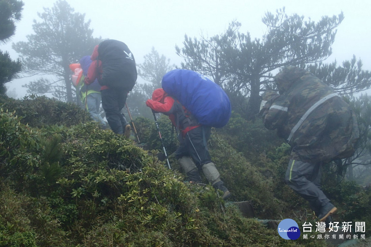 登山遇到降雨，請穿上兩截式雨衣褲，妥善固定背包套，做好防水(玉管處提供)