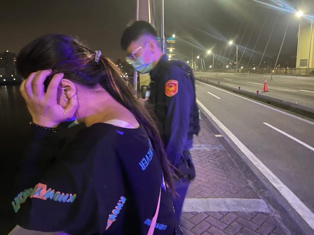 一名身穿黑色上衣女子站在重陽橋上人行道旁,停雙眼直視橋下河面,行徑詭異