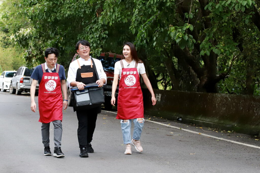 江坤俊醫師和韋汝與食堂廚師步行走在部落道路,親送便當給長輩