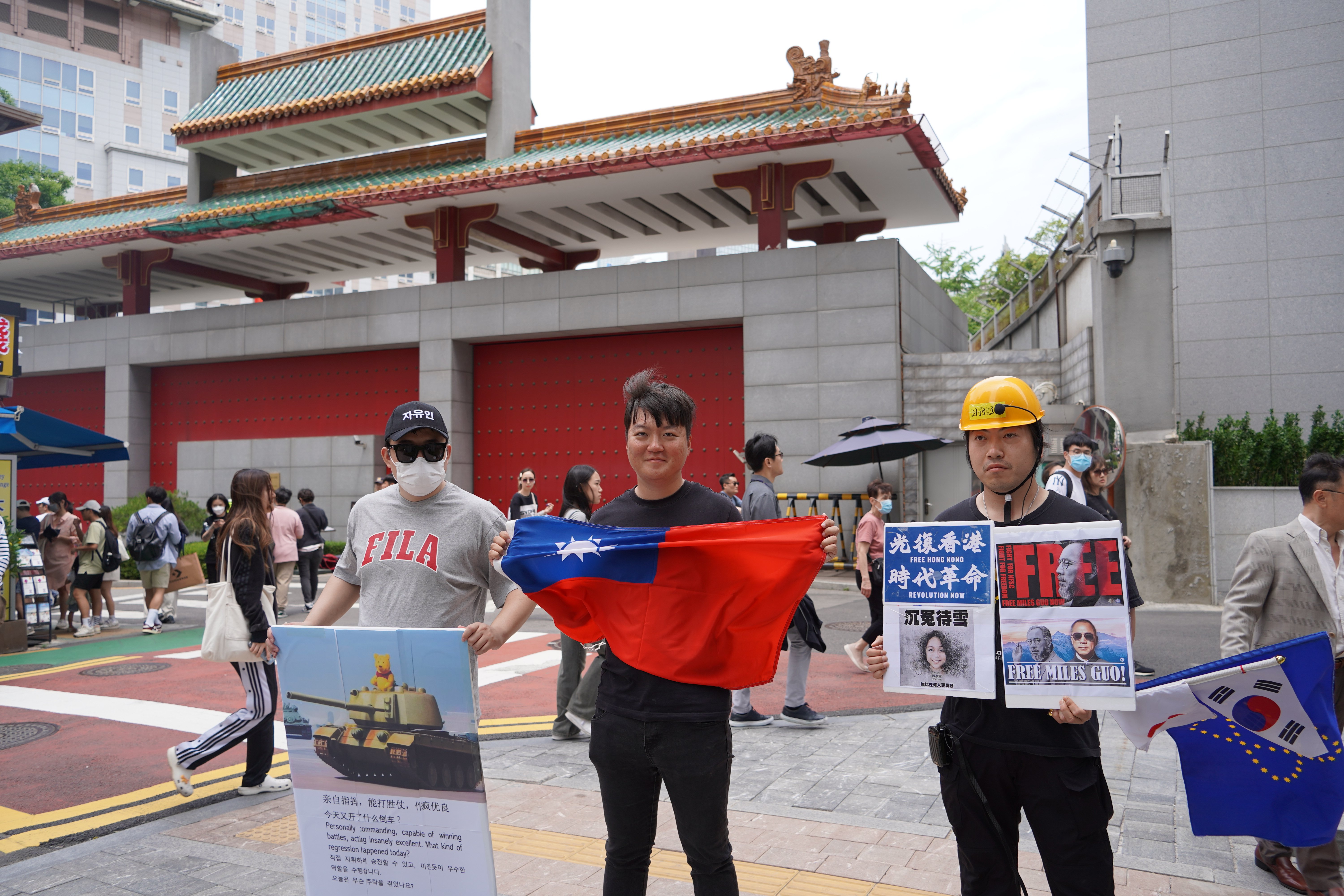 白紙運動的中國學生古金來(左)、韓籍社運人士洪在沅(中)和阿燦陽(右)在中國駐韓大使館前示威。吳珮如攝