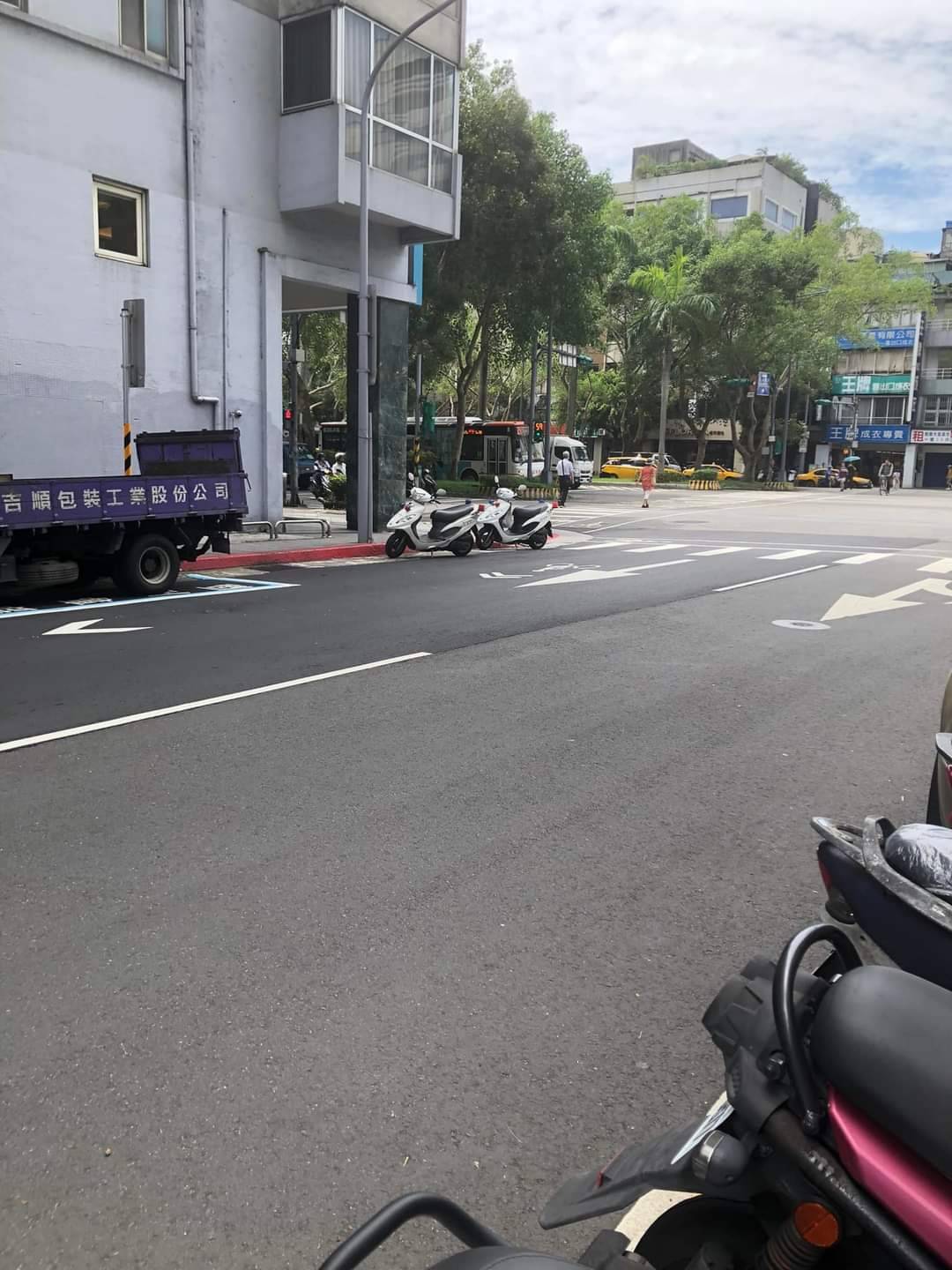2部警用機車停在路口斑馬線旁,議員汪志冰發現警員正在對面開單,認為當時並非緊急勤務,警員可從容將機車停在不影響交通處。(記者張欽翻攝)