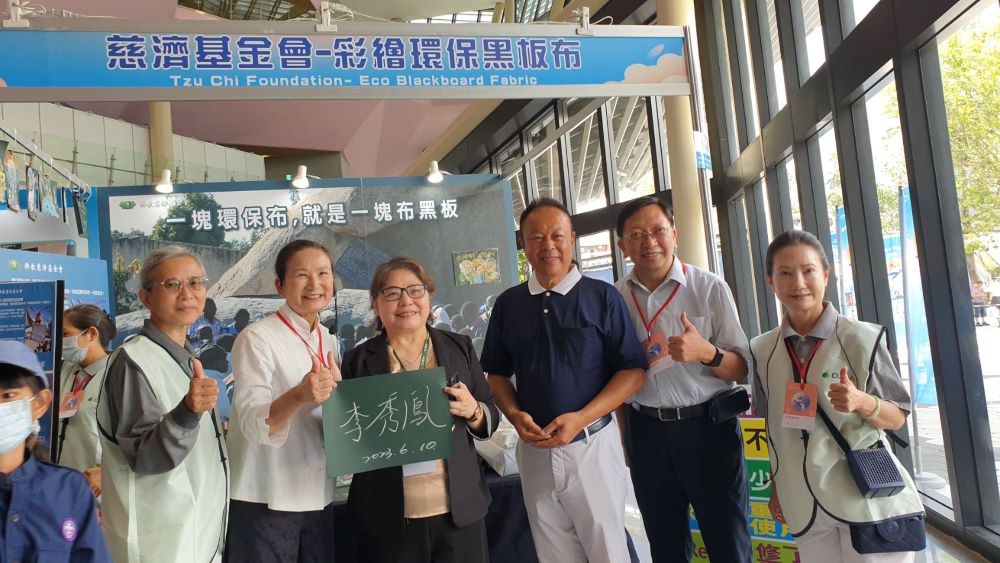 ▲科工館長李秀鳳(左三)拿著親筆簽名的黑板布與慈濟公傳鄭楊慶(右三)合影 (記者王雯玲翻攝)