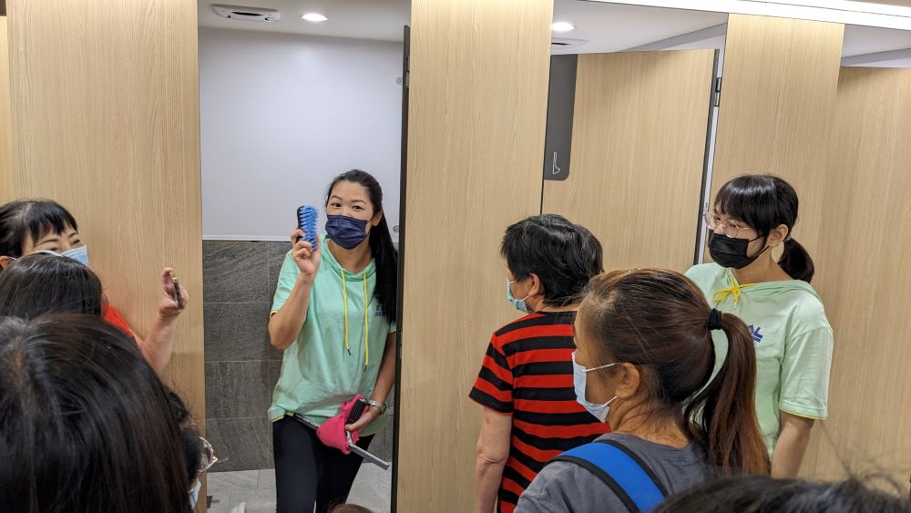 講師進行廁間清潔實作教學。〈環保局提供〉