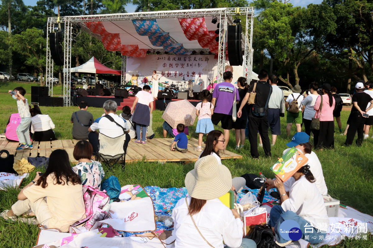 不少民眾在舞台前席地野餐聆聽歌手演唱。(記者扶小萍攝)
