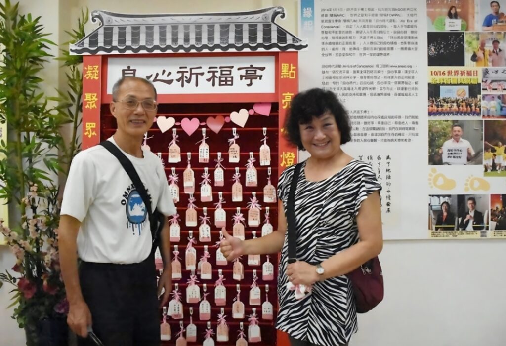 ▲來賓響應良心時代運動,寫下祈福卡開心繫掛祈福亭。(記者李欣翻攝)