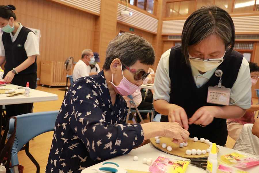 社區健康中心主任賴怡伶（右 ）協助長輩製作齒模。
