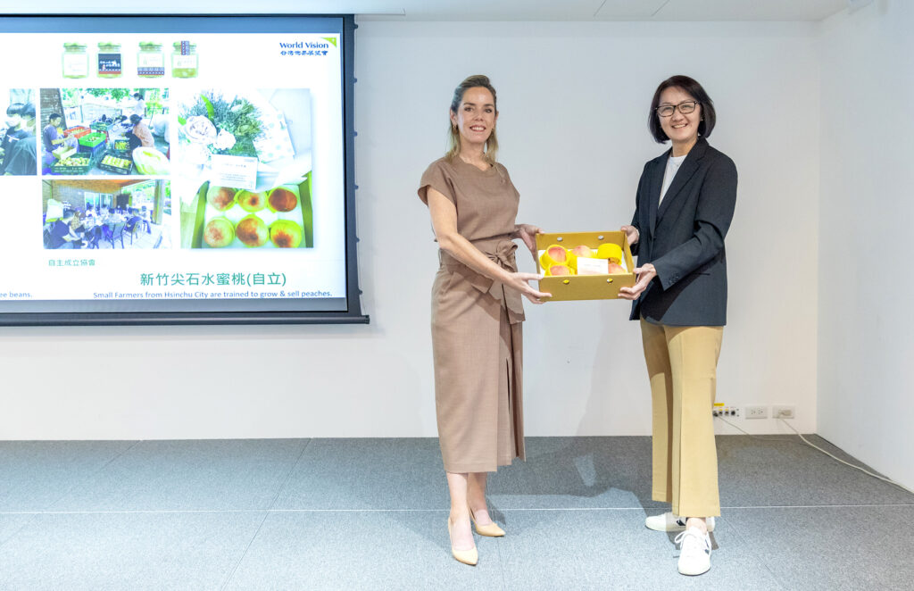 台灣世界展望會會長李紹齡(右)贈送巴拉圭準第一夫人Leticia Ocampos(左)由展望會國內服務團隊培力社區自立後出產的水蜜桃。(台灣世界展望會提供)