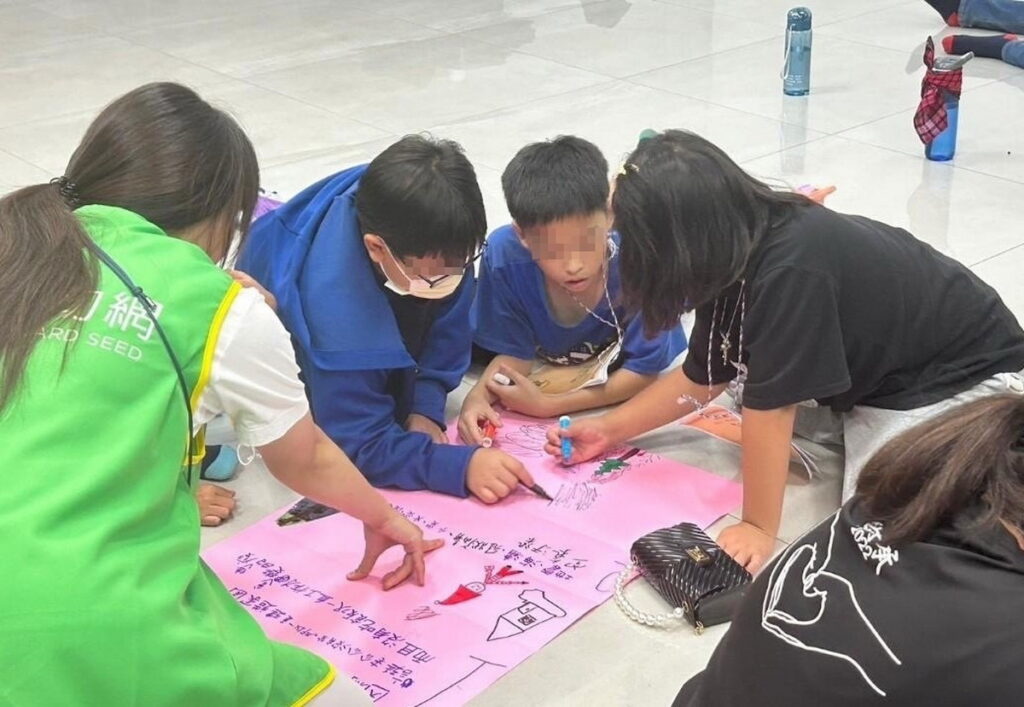 芥菜種會扶助的大專生擔任營隊小隊輔（左1），引導孩童認識災害