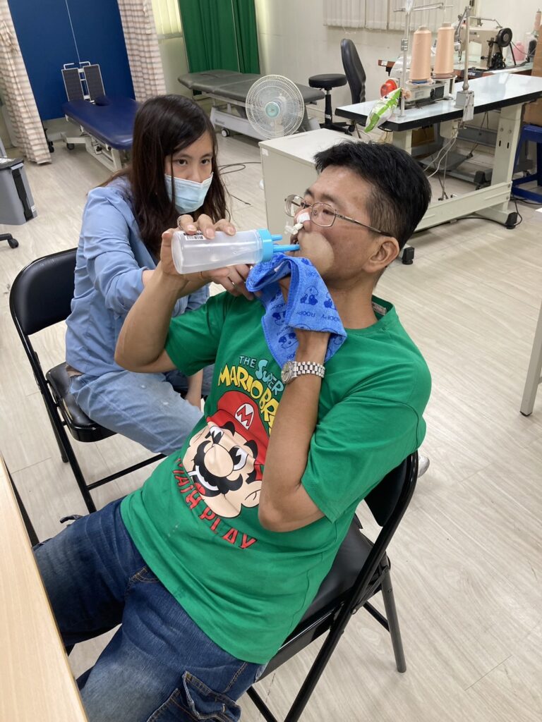 阿志大哥在陽光治療師指導下練習以口進食