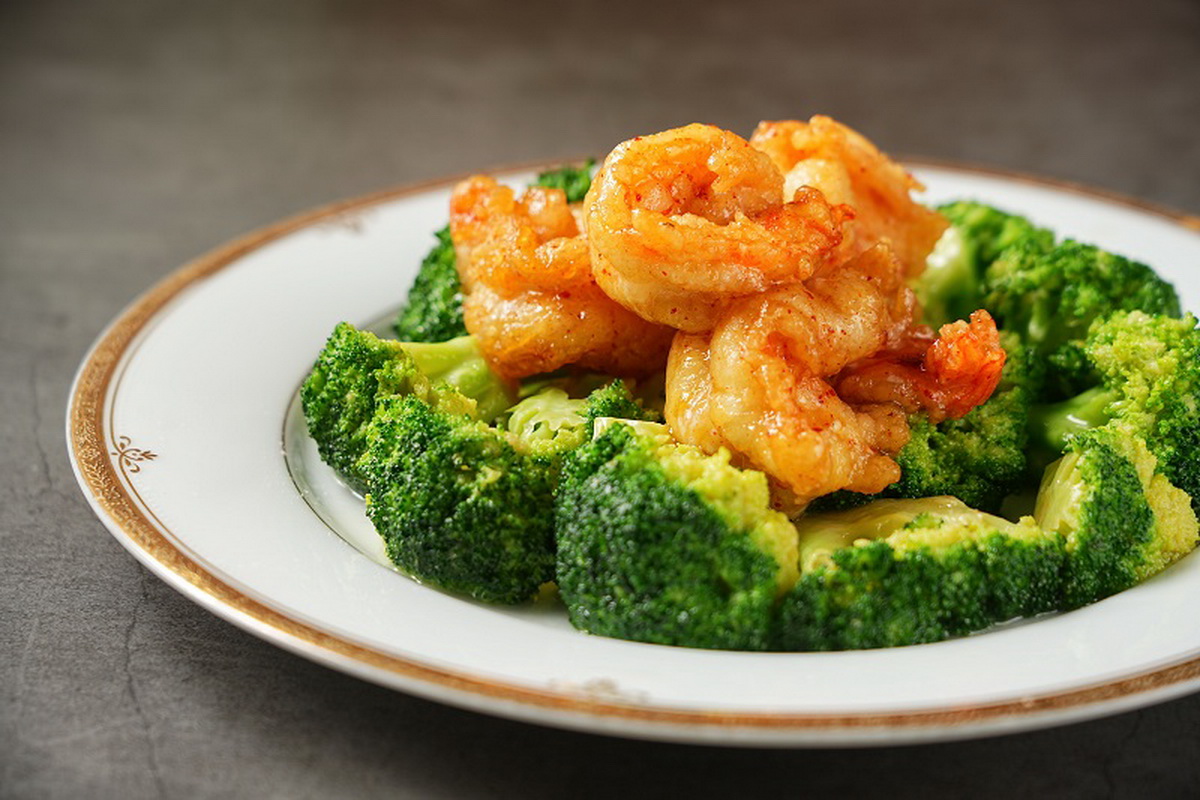 「金寶明蝦球」特選大明蝦裹粉後油炸,再加入主廚獨家研發的金寶醬汁,以紹興酒、檸檬汁、辣椒粉、辣椒油製成,與明蝦拌炒後再佐以西蘭花裝盤。(圖/神旺潮品集.忠孝店提供)