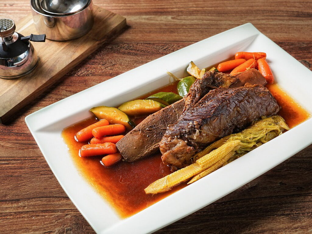 「鹽焗帶骨牛小」嚴選Choice帶骨牛小排,上桌時澆淋烈酒炙燒,絢麗的火焰搭配肉嫩甘甜,不論是聚餐或是宴客都超有面子。(圖/神旺潮品集.忠孝店提供)