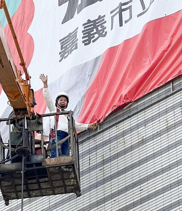 立委參選人張秀華競選首面大型看板 搭高空吊車升6層樓高掛看板