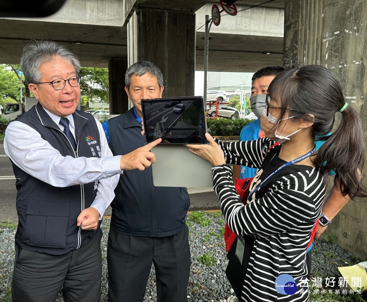 台中市環保局長陳宏益,透過路口監控器即時影像說明路口監視器監測汽車亂丟垃圾的精準度。(圖/記者賴淑禎攝)