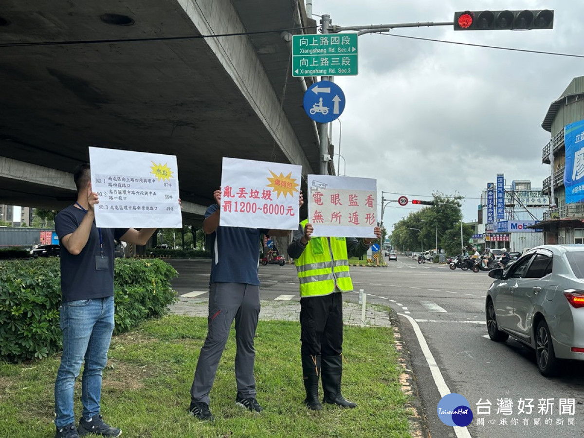 南屯區向上路與環中路交叉口已設置監控器,監控行經車輛亂丟垃圾情形,中市環保局人員在路口進行宣導。(圖/記者賴淑禎攝)