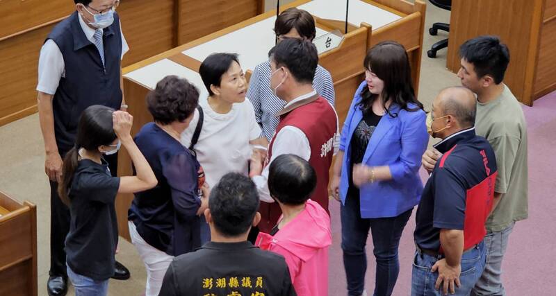 澎湖縣議會7日召開臨時會，議長劉陳昭玲（圖中白衣者）於會中宣布請辭，在她走下主席台後，與會議員給予安慰、擁抱。 中央社