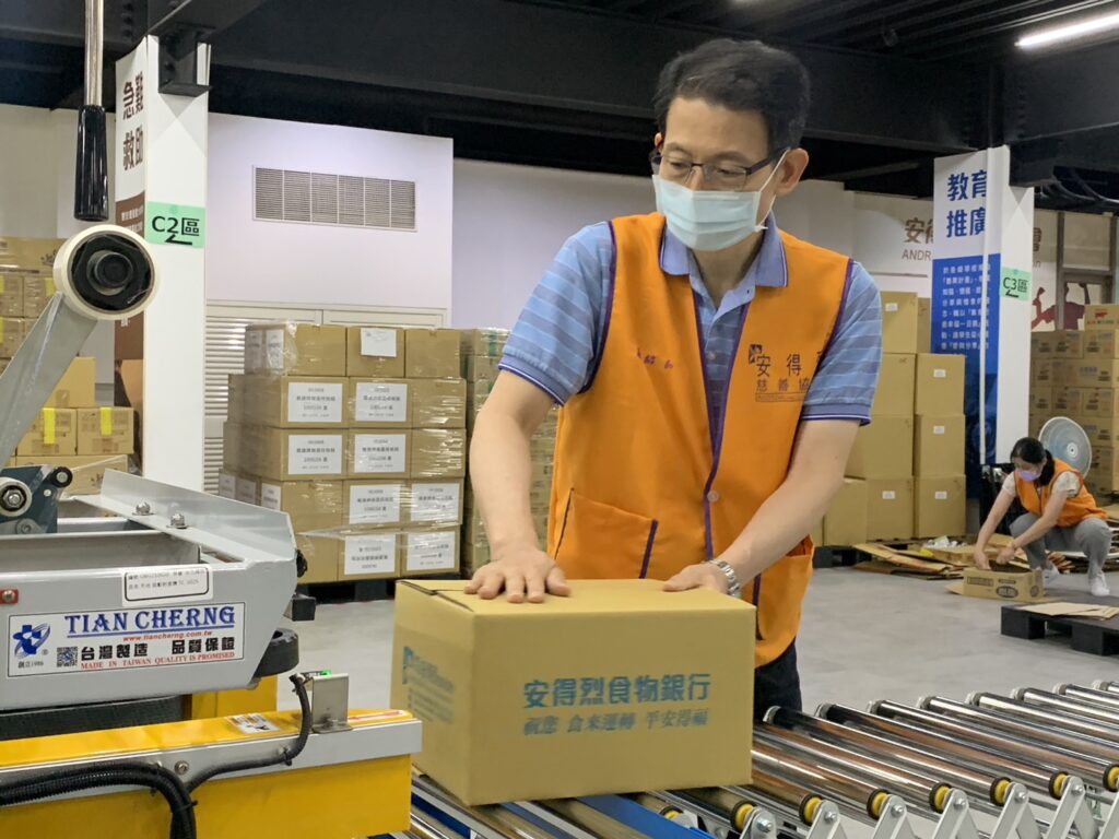 安得烈慈善協會羅紹和執行長與志工朋友們一起包裝安心食物箱。
