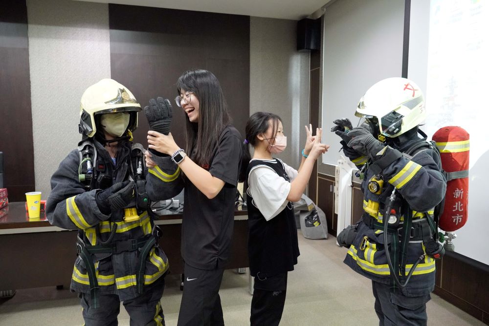 《圖說》新北女孩體驗重達20公斤的消防救災裝備。〈社會局提供〉