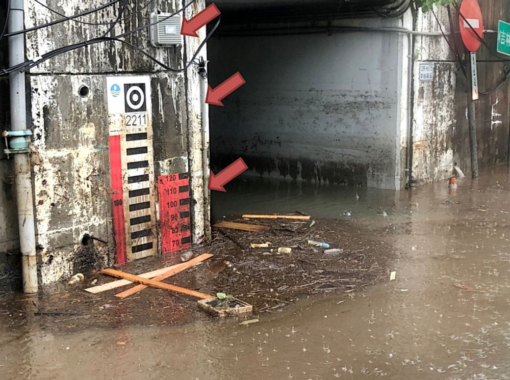 《圖說》110年6月4日午後強降雨造成汐止南陽街地下道積淹水之情形,紅箭頭處為「淹水感測器」。〈水利局提供〉