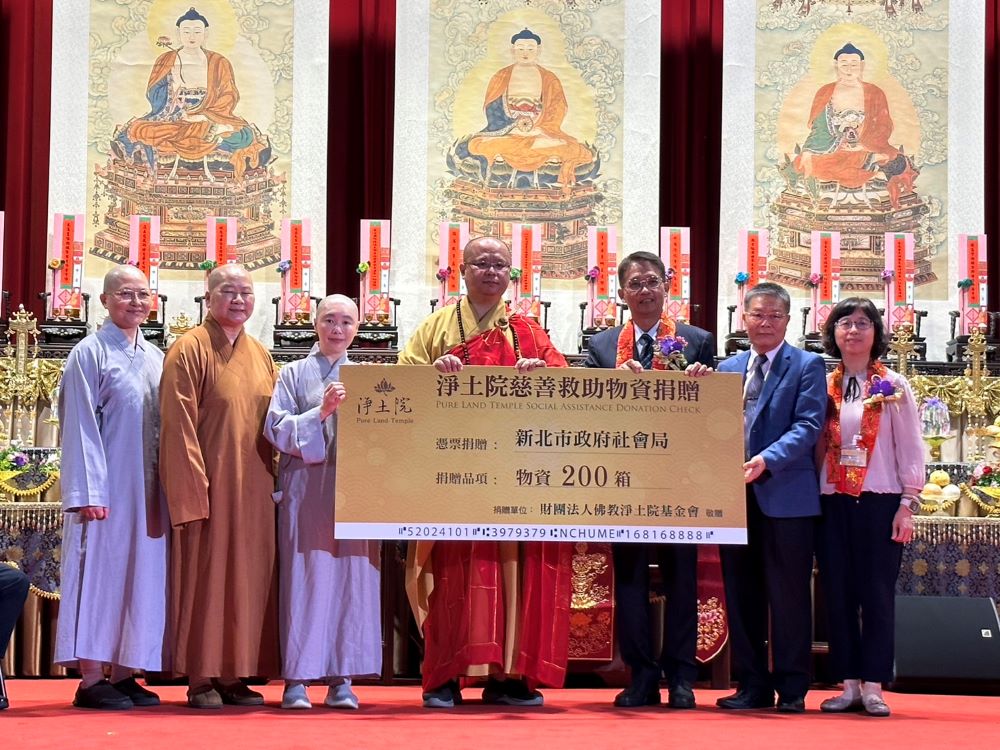 《圖說》淨土院基金會釋自誠法師(中)代表捐贈200箱物資,由邱敬斌(右3)代表市府受贈,右一社會局副局長許秀能。〈社會局提供〉