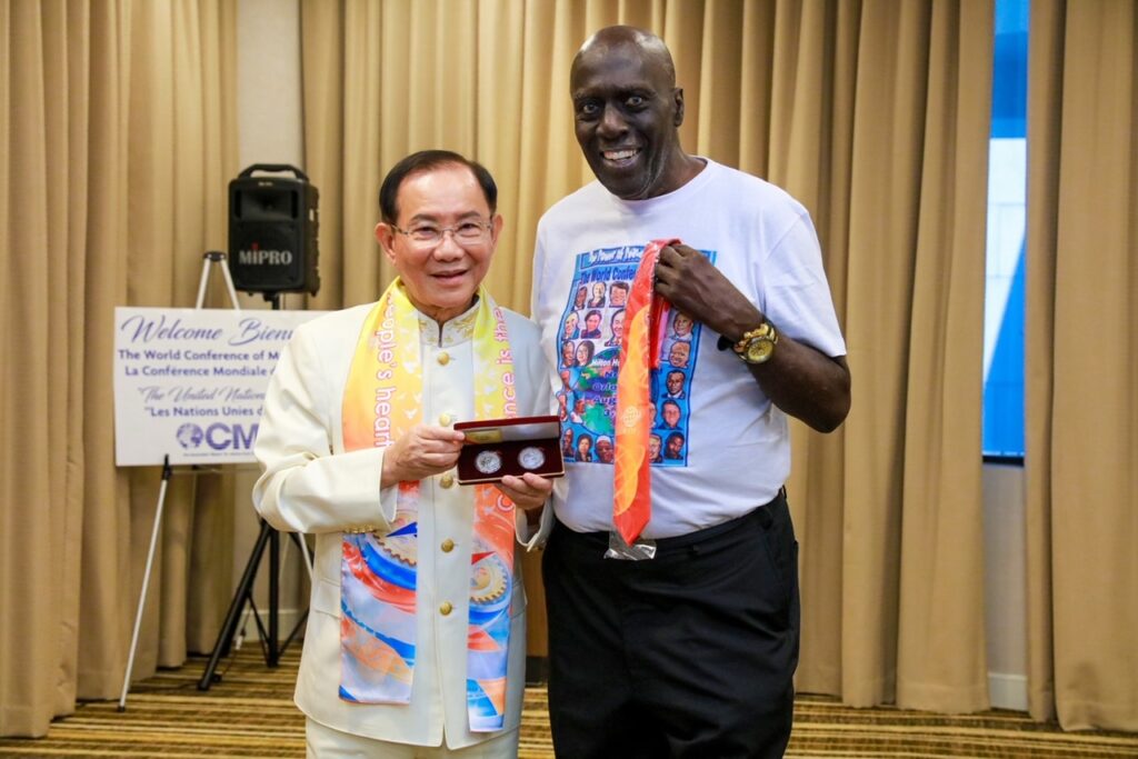 ▲洪博士致贈紀念銀幣給前哈林環球旅行者籃球明星Bobby Hunter。（記者李欣翻攝）