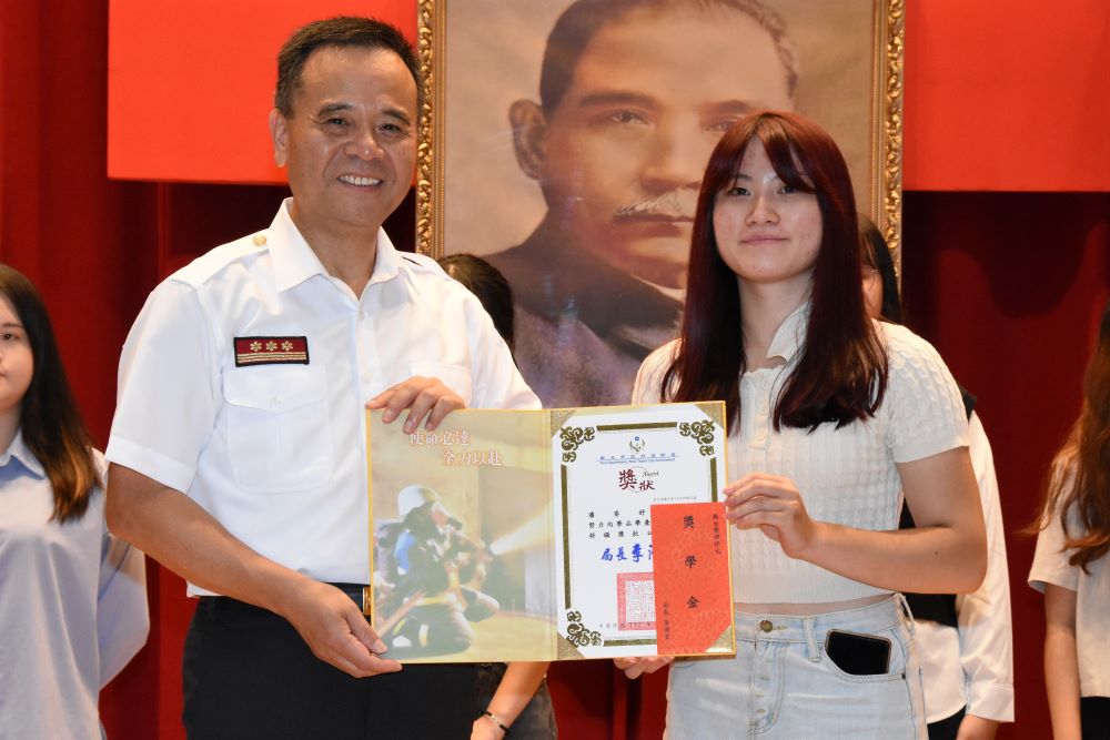 《圖說》李清安局長頒獎予二重分隊小隊長潘志杰女兒潘姿妤同學。〈消防局提供〉