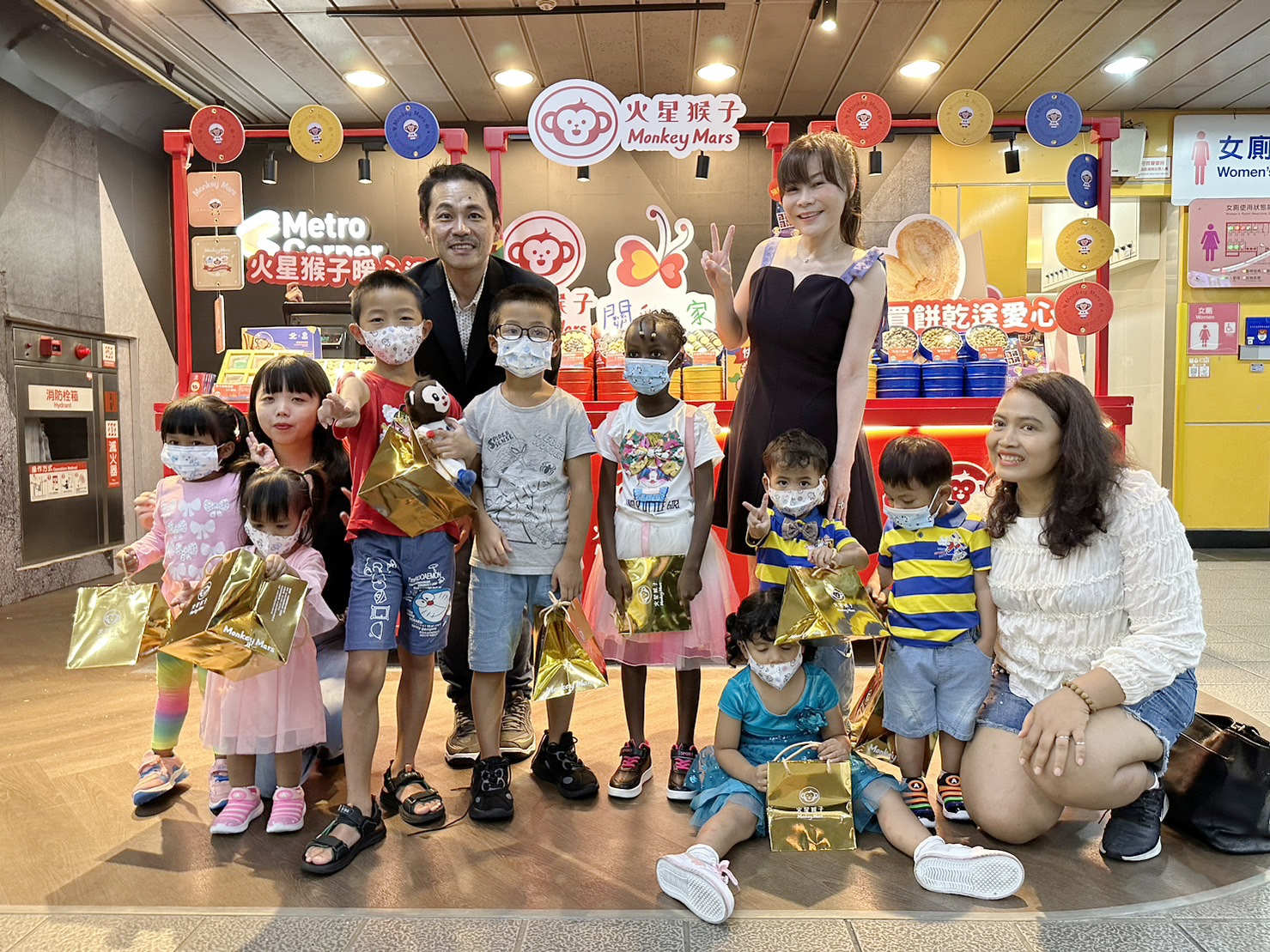 「火星猴子」在台北捷運市府站快閃店,邀請知名電視主持人錢怡君(後右一)擔任一日店長,帶著「等家寶寶」一起做愛心,後左一為火星猴子總經理李佳穎。(圖/火星猴子提供)