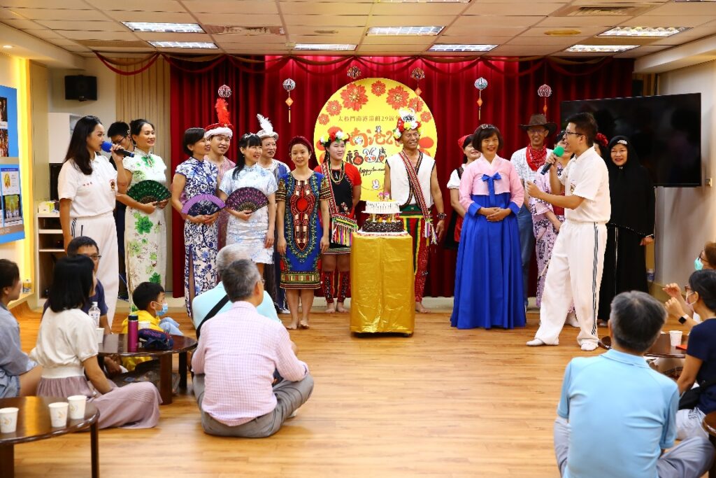 ▲穿著各國服飾的祝賀團代表「世界一家」歡聚一堂,與嘉賓一起為南港館慶生及切生日蛋糕。(記者李欣翻攝)