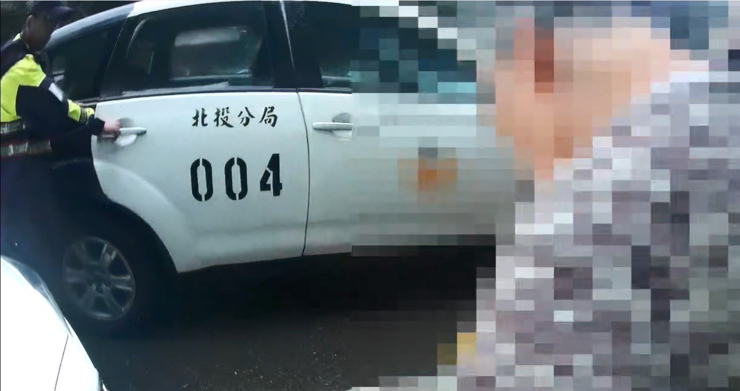 黃姓婦人迷途不慎跌倒，北投分局光明所副所長賴星光（左）及警員章庭瑋攙扶老婦人上警車並護送返家。(記者宋紹誠翻攝)