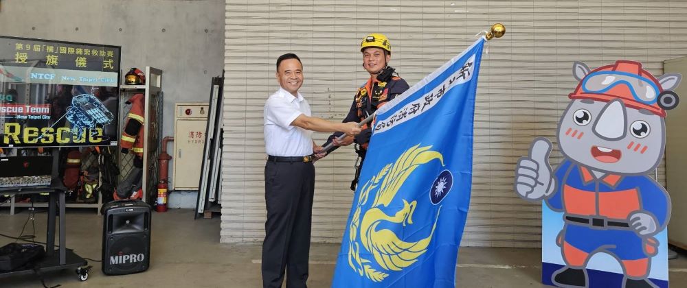 《圖說》新北市消防局長李清安今日為將前往日本參加第9屆"Ch'iao"國際繩索救助賽的慈福分隊7名優秀隊員舉行授旗儀式。〈消防局提供〉