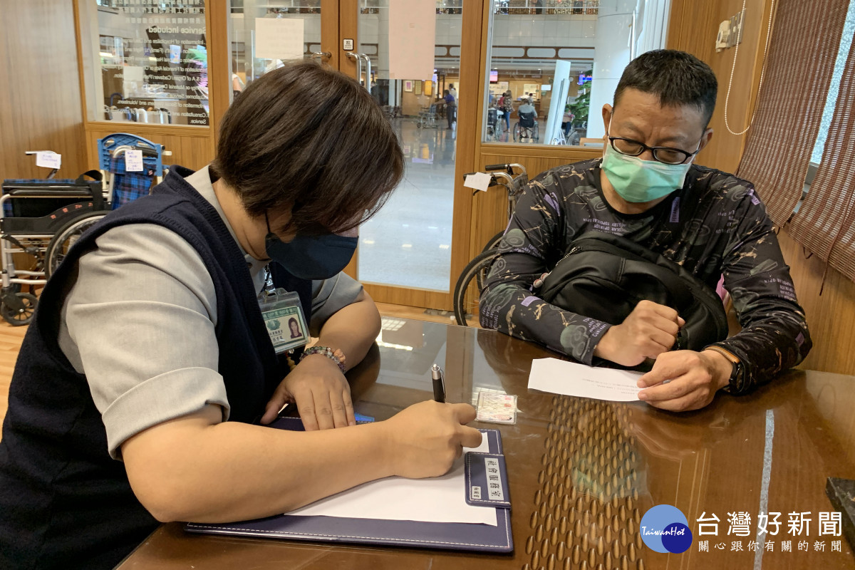 獲大愛肝臟移植的郭先生(右)到台中慈院社會服務室填寫捐款資料,護持醫療體系運作,幫助更多病人。