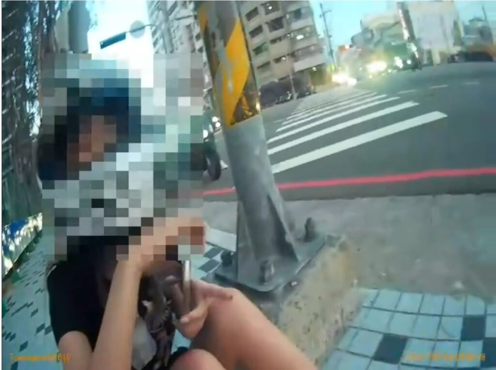 ▲圖說:陳女因機車發生碰撞倒於路中,員警將其抱路旁等待救援 (圖/台中市政府提供)
