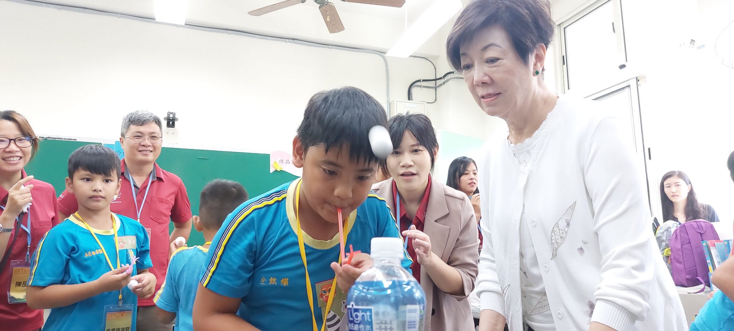 台積電慈善基金會張淑芬董事長與志工在雙龍國小藉遊戲介紹伯努力利定定律。(圖/台積電慈善基金會)