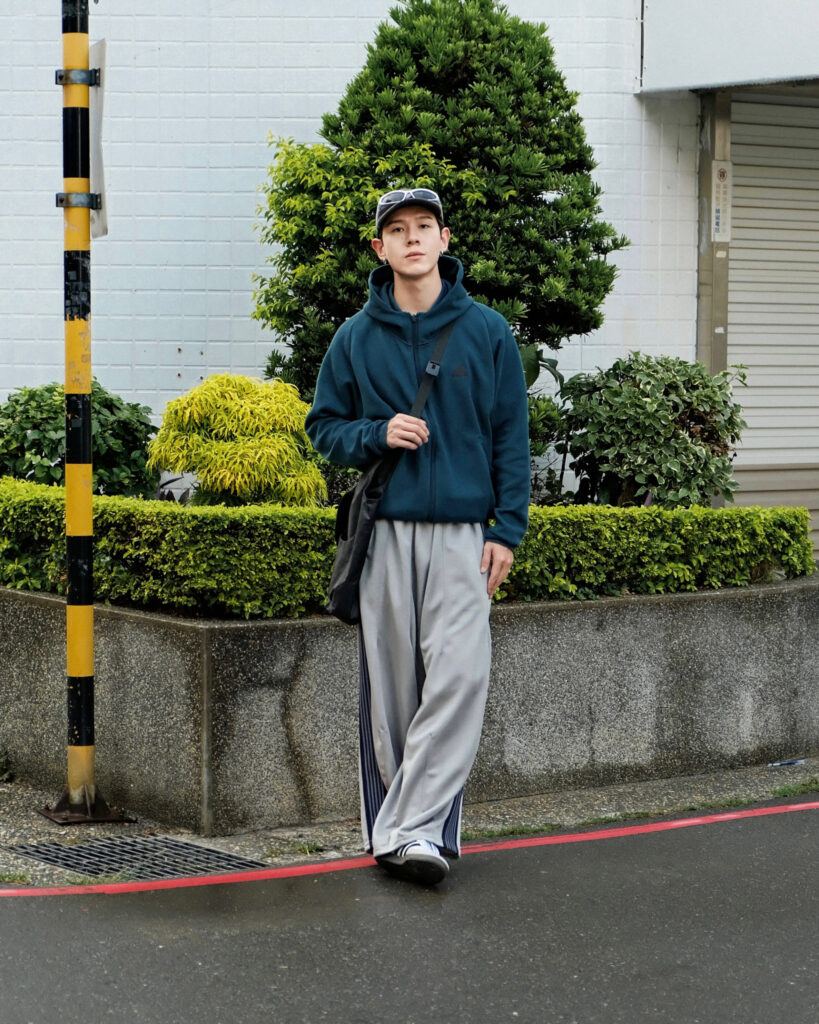 全新adidas Z.N.E.系列藍綠色外套搭配落地寬褲，長褲側邊線條與外套相呼應，打造回頭率十足的日系City Boy造型