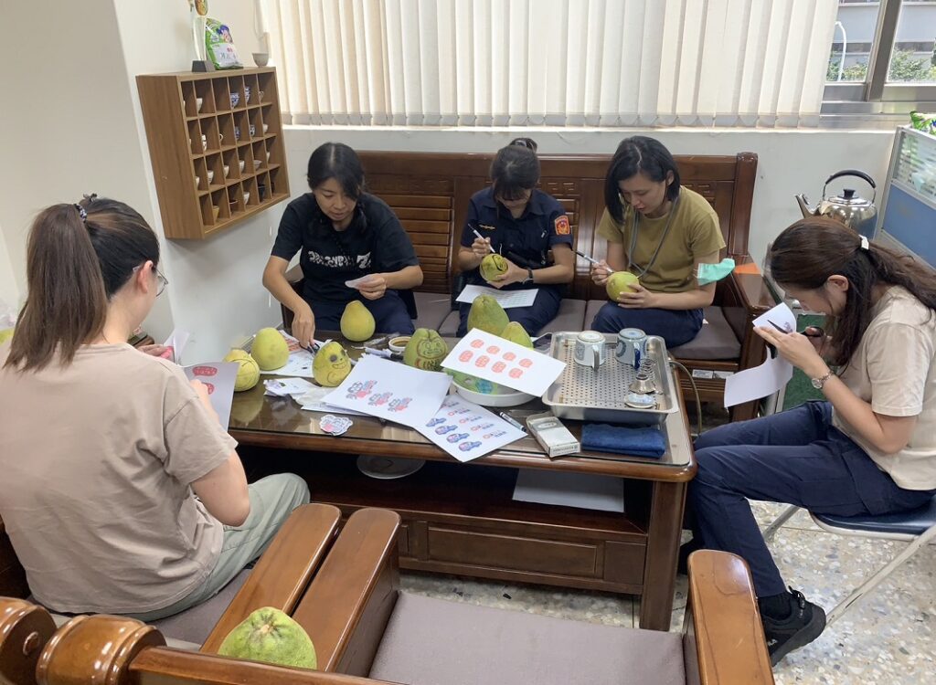 ▲圖說:四分局員警聚精會神在柚子上揮毫作畫展創意 (圖/台中市政府提供)