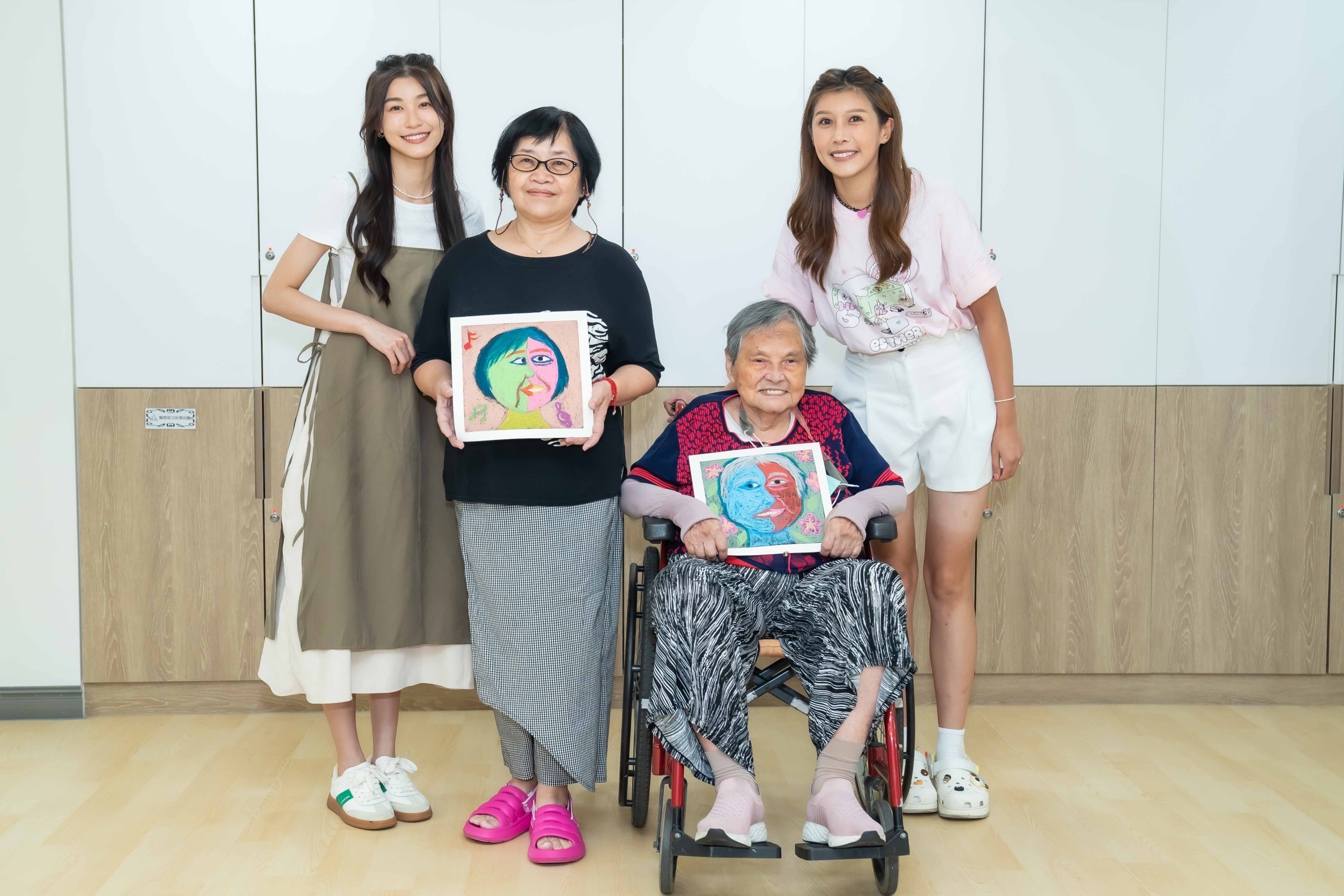 「孫睿」與 「陳俋塵」一起陪伴中心的爺爺奶奶們，透過藝術彩繪的方式，畫出幸福的臉譜。(照片/紅心字會提供)