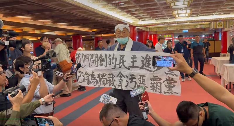 民進黨創黨元老之一的魏耀乾,昨在民進黨37周年創黨黨員餐會,舉白布條抗議,痛斥民進黨背離民意,已成惡霸黨。圖/引自樊啓明臉書